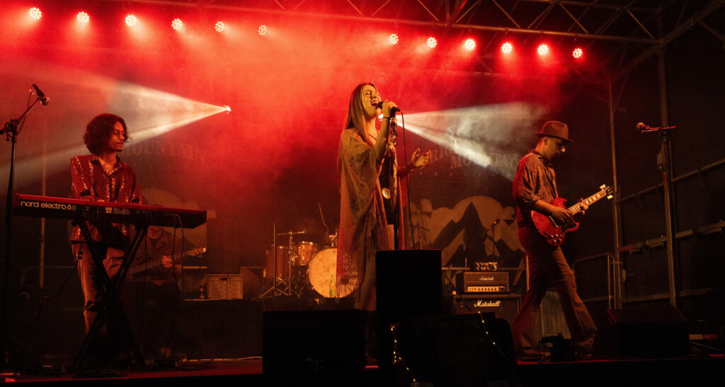 Crimson Roots vocalist performing under red stage lights