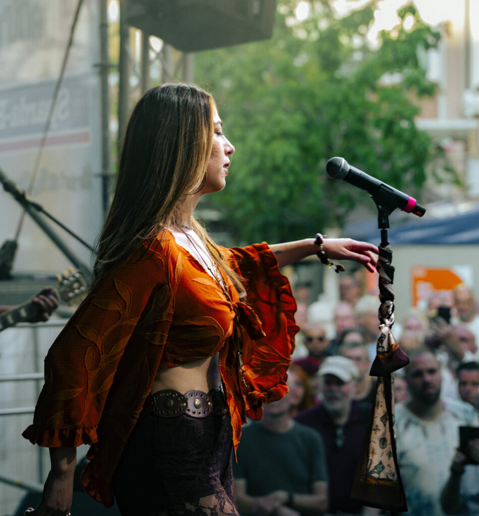 Crimson Roots vocalist performing at an outdoor concert